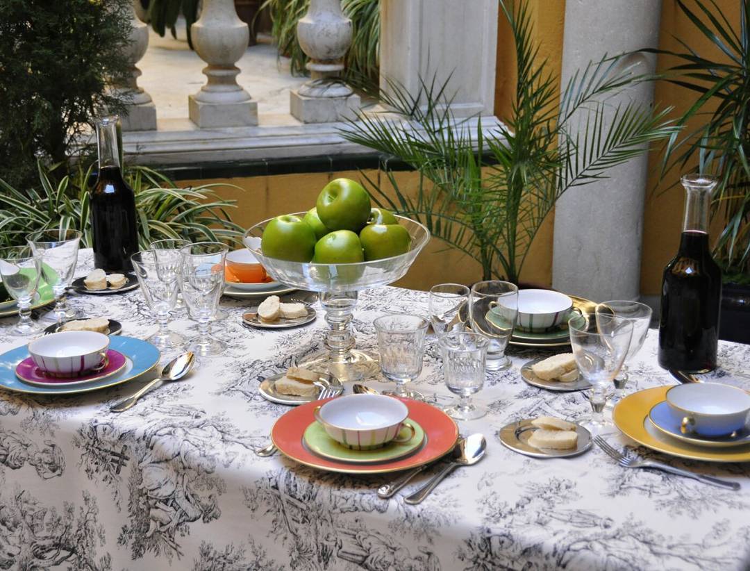 Mesa con vajilla y frutero de cristal decorada con cítricos. Especialistas en listas de boda Cuidada selección de artículos de mesa y decoración